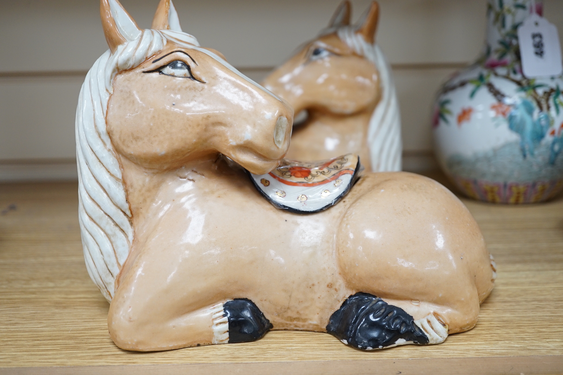 A pair of Chinese ceramic seated horses, 18cm high